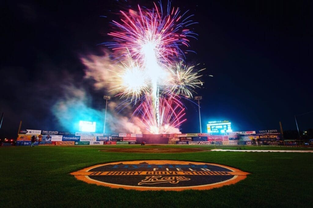 Colorful Fireworks Explode in the Night Sky Above the Stadium Illuminating the Field with Its Large Circular Frederick Keys Logo Advertisements Line the Outfield Fence and a Scoreboard Glowsperfect for Celebrating After a Big Game on the Frederick Keys Schedule