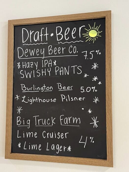 a Blackboard Menu Titled Draft Beer Lists Dewey Beer Co Hazy Ipa Swishy Pants 75 Burlington Beer Lighthouse Pilsner 50 and Big Truck Farm Lime Cruiser Lime Lager 4 Enjoy These Brews with the Best Burger Frederick Md Has to Offer a Yellow Sun Decorates the Top Right Corner