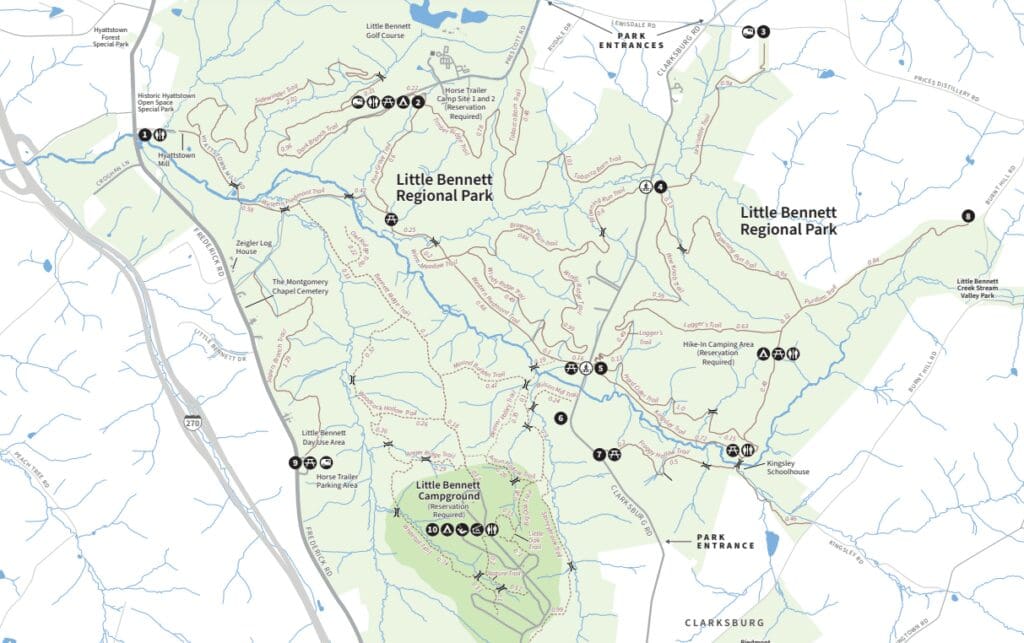 Map of Little Bennett Regional Park showing roads, creeks, trails including Little Bennett Bike Trails, campgrounds, and park entrances. Key locations like day use areas, visitor center, restrooms, and parking lots are marked with black icons throughout the park.