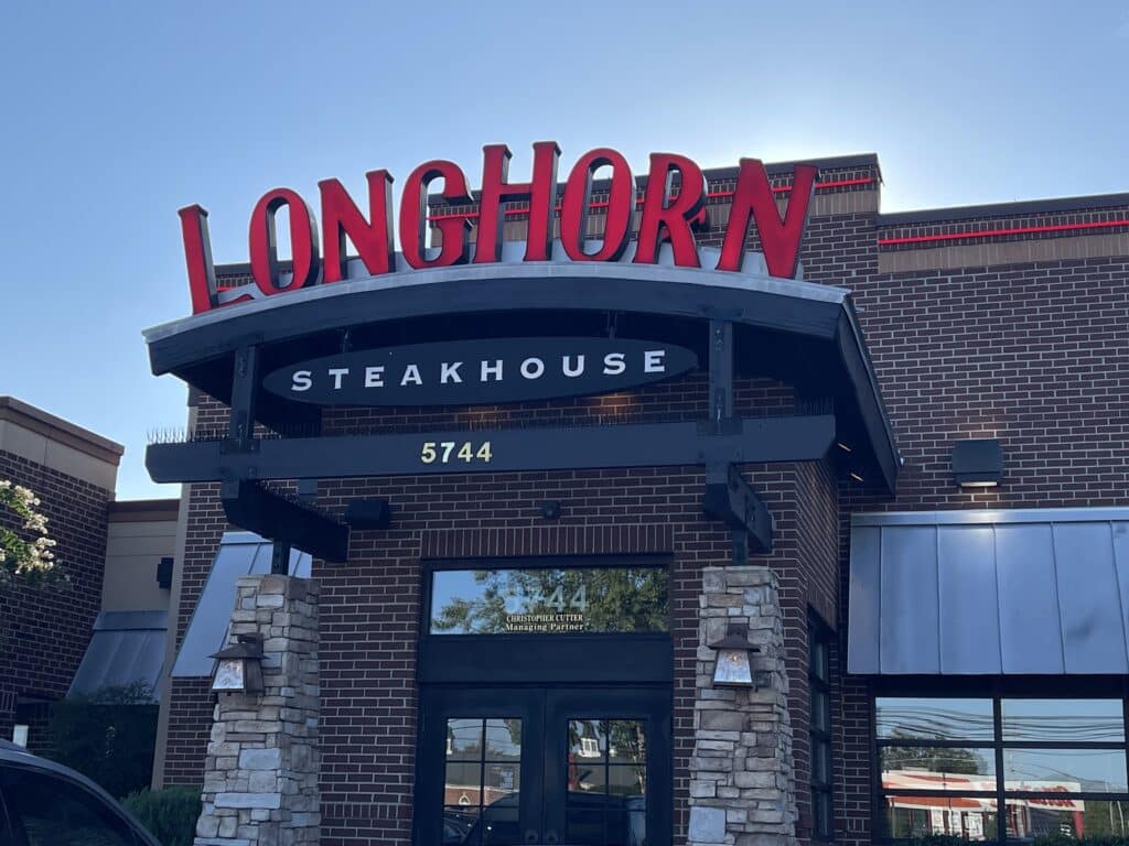 a Longhorn Steakhouse Restaurant Exterior in Frederick Md with Large Red Longhorn Letters Above a Black Steakhouse Awning and the Number 5744showcasing Why Its Considered the Best Steakhouse Frederick Md Has to Offer