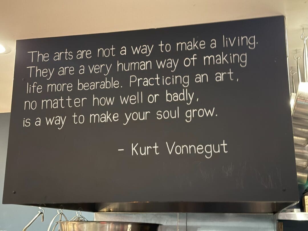 a Black Sign with White Typewritten Text Reads the Arts Are Not a Way to Make a Living at Market Table Bistro Theyre Seen As a Very Human Way of Making Life More Bearablea Practice That Helps Your Soul Grow  Kurt Vonnegut