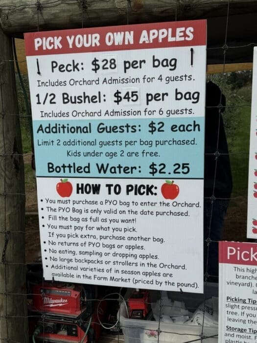 a Sign at Gaver Farm Titled pick Your Own Apples Lists Prices 1 Peck is $28 Per Bag 12 Bushel is $45 Per Bagboth Include Orchard Admission for 6 Guests Extra Guests Are $2 Each and Bottled Water is $225 Apple picking Instructions Follow Below