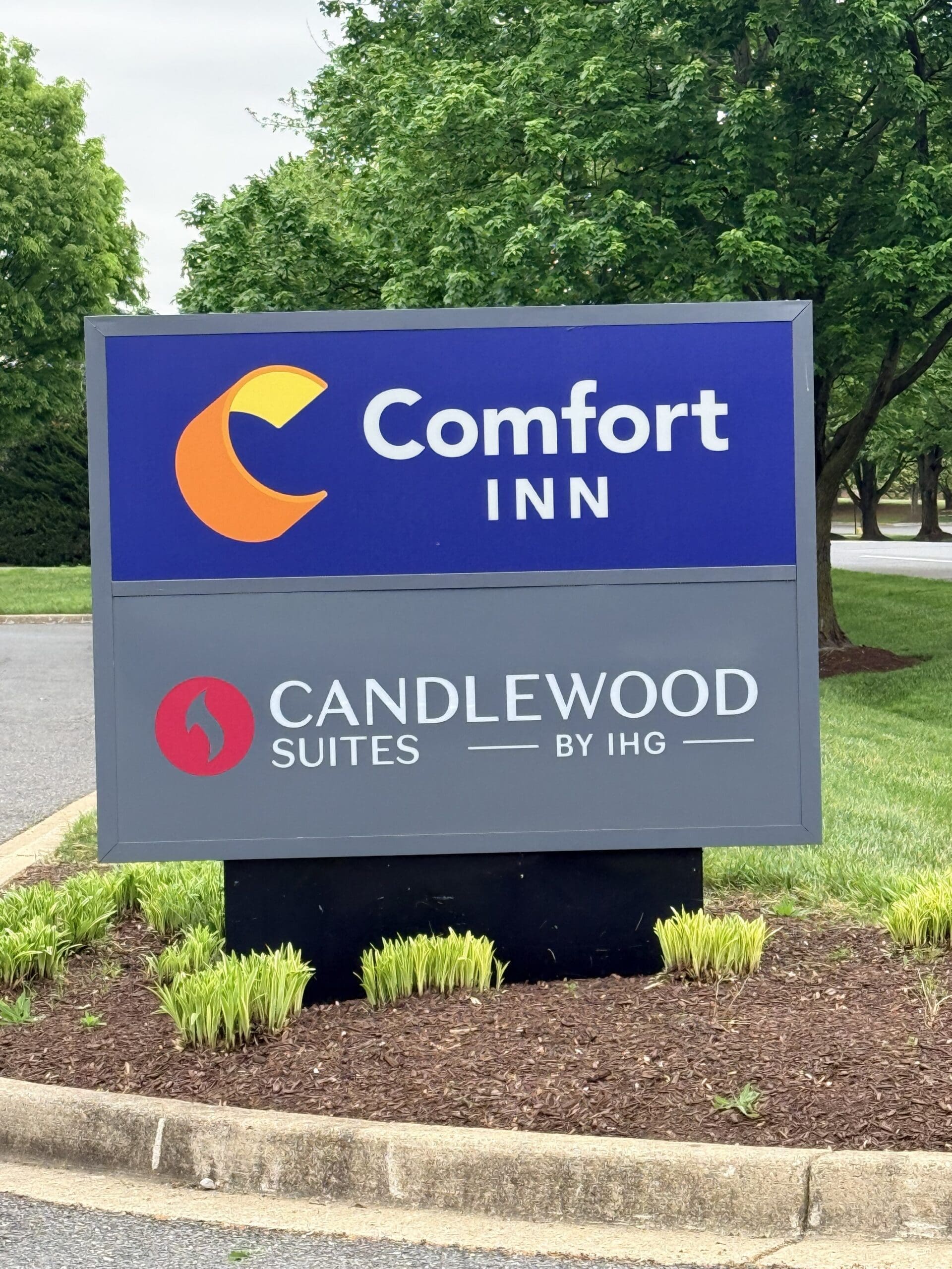 Blue Comfort Inn Sign with Orange Crescent Logo Advertising Candlwood Suites by Ihg Set Among Green Trees and Landscaped Ground Some of the Best Cheap Hotels in Frederick Md